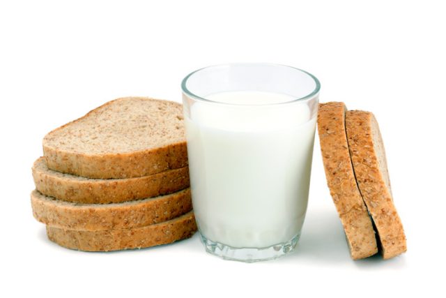 Glass of milk and sliced bread isolated on white background